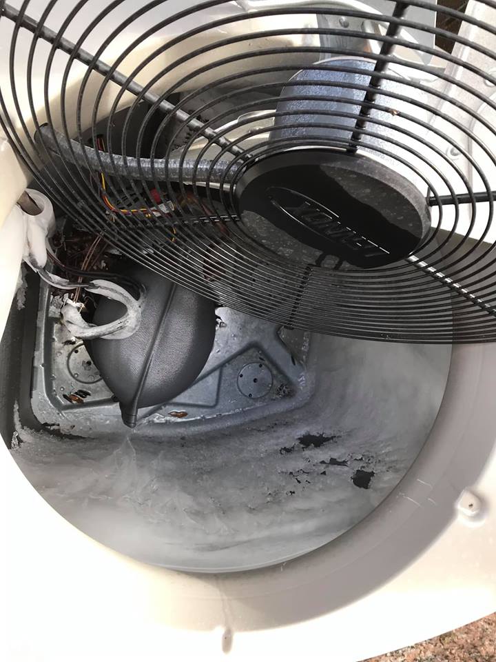 Completely frozen evaporator coil inside an AC unit — a common cause of AC not cooling, found during AC repair service